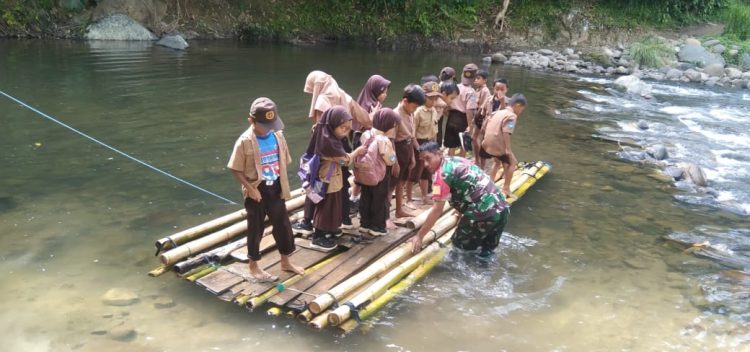 Babinsa di Polman Bantu Anak-Anak Sekolah Menyeberang Sungai dengan Rakit Bambu